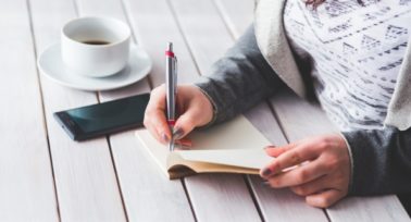 woman writing on a notepad